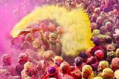 İnsanlar 9 Mart 2025 'te Hindistan' ın Mathura kentinde Nandji Tapınağı 'ndaki Lathmar Holi festivali sırasında birbirlerine renkli pudra sürerler.. 