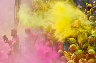 İnsanlar 9 Mart 2025 'te Hindistan' ın Mathura kentinde Nandji Tapınağı 'ndaki Lathmar Holi festivali sırasında birbirlerine renkli pudra sürerler.. 
