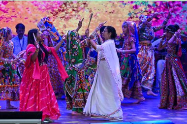 KOLKATA INDIA - 12 Mart 2025 tarihinde Kolkata Hindistan 'daki Dhanyo Auditoryumu' nda Holi öncesi Dolyatra ve Holi Milan Utsav adlı dandiya dansının ritmiyle dans etti.