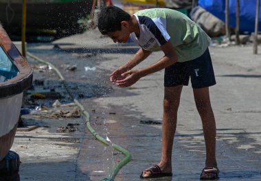 MUMBAI, INDIA - 22 Mart: bir çocuk Mumbai Worli Koliwad 'da sıcakta serinlemek için yüzünü yıkadı. Son günlerde Mumbai 'de sıcaklık önemli ölçüde arttı, 22 Mart 2025' te Mumbai, Hindistan 'da.. 