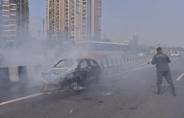 GHAZIABAD, INDIA - 26 Mart 2025 'te Delhi Meerut Otoyolu' nda, bir arabanın lastikleri patladıktan sonra hasar gören bir Baleno arabası aniden alev aldı ve 26 Mart 2025 'te Hindistan' ın Gaziabad kentinde tüm araba alev aldı.. 