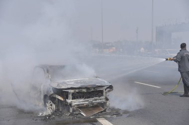GHAZIABAD, INDIA - 26 Mart 2025 'te Delhi Meerut Otoyolu' nda, bir arabanın lastikleri patladıktan sonra hasar gören bir Baleno arabası aniden alev aldı ve 26 Mart 2025 'te Hindistan' ın Gaziabad kentinde tüm araba alev aldı.. 