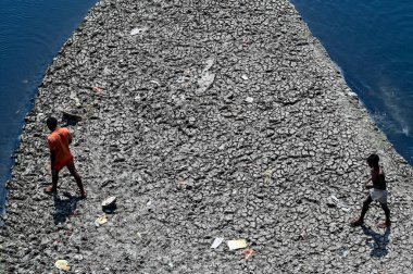 NEW DELHI, INDIA - 26 Mart 2025: nehir yatağı görülebilir ve Yamuna 'nın 26 Mart 2025' te Yeni Delhi, Hindistan 'da kuruduğunu gören ITO barajı boyunca akan sadece küçük bir dere. Yeni BJP hükümet gündeminin merkezinde Yamuna 'nın temizlenmesi yer alıyor.