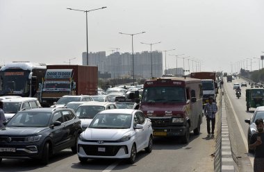 GHAZIABAD, INDIA - 26 Mart 2025: Ghaziabad, Hindistan 'da 26 Mart 2025 tarihinde Ghaziabad, Delhi Meerut Otoyolu yakınlarında yanan bir araba nedeniyle otoyolda yoğun trafik sıkışıklığı yaşandı. İtfaiye ekibi olay yerine vardı ve yangını söndürdü..