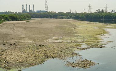 NEW DELHI, INDIA - 26 Mart 2025: nehir yatağı görülebilir ve Yamuna 'nın 26 Mart 2025' te Yeni Delhi, Hindistan 'da kuruduğunu gören ITO barajı boyunca akan sadece küçük bir dere. Yeni BJP hükümet gündeminin merkezinde Yamuna 'nın temizlenmesi yer alıyor.