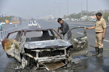 GHAZIABAD, INDIA - 26 Mart 2025 'te Delhi Meerut Otoyolu' nda, bir arabanın lastikleri patladıktan sonra hasar gören bir Baleno arabası aniden alev aldı ve 26 Mart 2025 'te Hindistan' ın Gaziabad kentinde tüm araba alev aldı.. 