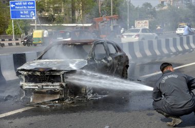 GHAZIABAD, INDIA - 26 Mart 2025 'te Delhi Meerut Otoyolu' nda, bir arabanın lastikleri patladıktan sonra hasar gören bir Baleno arabası aniden alev aldı ve 26 Mart 2025 'te Hindistan' ın Gaziabad kentinde tüm araba alev aldı.. 