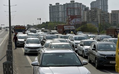 GHAZIABAD, INDIA - 26 Mart 2025: Ghaziabad, Hindistan 'da 26 Mart 2025 tarihinde Ghaziabad, Delhi Meerut Otoyolu yakınlarında yanan bir araba nedeniyle otoyolda yoğun trafik sıkışıklığı yaşandı. İtfaiye ekibi olay yerine vardı ve yangını söndürdü..