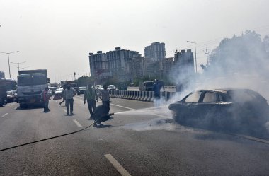 GHAZIABAD, INDIA - 26 Mart 2025 'te Delhi Meerut Otoyolu' nda, bir arabanın lastikleri patladıktan sonra hasar gören bir Baleno arabası aniden alev aldı ve 26 Mart 2025 'te Hindistan' ın Gaziabad kentinde tüm araba alev aldı.. 
