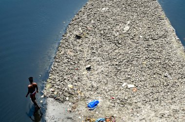 NEW DELHI, INDIA - 26 Mart 2025: nehir yatağı görülebilir ve Yamuna 'nın 26 Mart 2025' te Yeni Delhi, Hindistan 'da kuruduğunu gören ITO barajı boyunca akan sadece küçük bir dere. Yeni BJP hükümet gündeminin merkezinde Yamuna 'nın temizlenmesi yer alıyor.