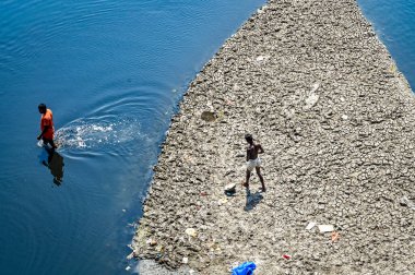 NEW DELHI, INDIA - 26 Mart 2025: nehir yatağı görülebilir ve Yamuna 'nın 26 Mart 2025' te Yeni Delhi, Hindistan 'da kuruduğunu gören ITO barajı boyunca akan sadece küçük bir dere. Yeni BJP hükümet gündeminin merkezinde Yamuna 'nın temizlenmesi yer alıyor.