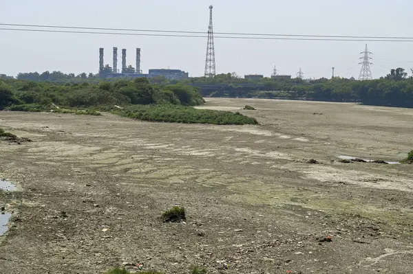 NEW DELHI, INDIA - 26 Mart 2025: nehir yatağı görülebilir ve Yamuna 'nın 26 Mart 2025' te Yeni Delhi, Hindistan 'da kuruduğunu gören ITO barajı boyunca akan sadece küçük bir dere. Yeni BJP hükümet gündeminin merkezinde Yamuna 'nın temizlenmesi yer alıyor.