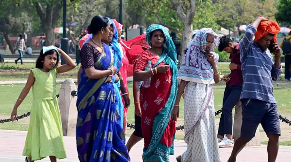 NEW DELHI, INDIA - 26 Mart 2025 tarihinde Yeni Delhi, Hindistan 'da sıcak öğleden sonra Kartavya Yolu' nda ziyaretçiler. Delhi bu sezonun en sıcak gününü, maksimum sıcaklık 37,1 santigrat dereceye yükselerek 25 Mart Salı günü kaydetti.. 