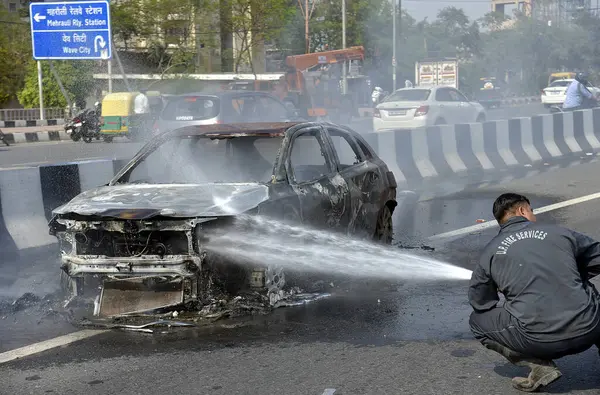GHAZIABAD, INDIA - 26 Mart 2025 'te Delhi Meerut Otoyolu' nda, bir arabanın lastikleri patladıktan sonra hasar gören bir Baleno arabası aniden alev aldı ve 26 Mart 2025 'te Hindistan' ın Gaziabad kentinde tüm araba alev aldı.. 