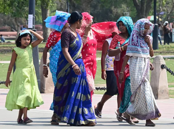NEW DELHI, INDIA - 26 Mart 2025 tarihinde Yeni Delhi, Hindistan 'da sıcak öğleden sonra Kartavya Yolu' nda ziyaretçiler. Delhi bu sezonun en sıcak gününü, maksimum sıcaklık 37,1 santigrat dereceye yükselerek 25 Mart Salı günü kaydetti.. 