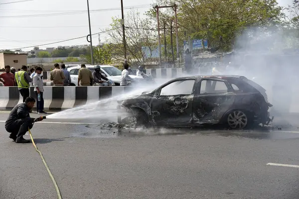 GHAZIABAD, INDIA - 26 Mart 2025 'te Delhi Meerut Otoyolu' nda, bir arabanın lastikleri patladıktan sonra hasar gören bir Baleno arabası aniden alev aldı ve 26 Mart 2025 'te Hindistan' ın Gaziabad kentinde tüm araba alev aldı.. 