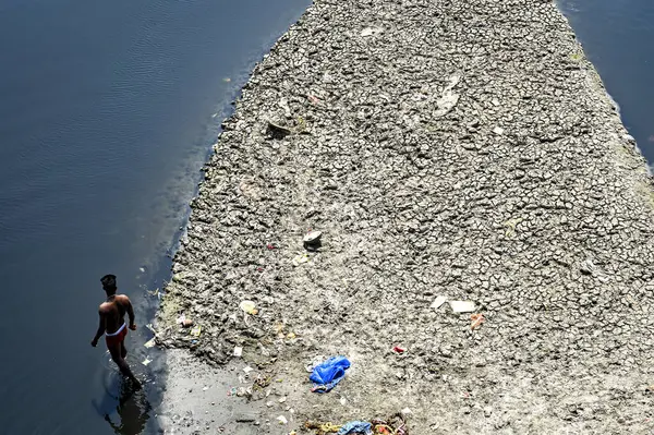 NEW DELHI, INDIA - 26 Mart 2025: nehir yatağı görülebilir ve Yamuna 'nın 26 Mart 2025' te Yeni Delhi, Hindistan 'da kuruduğunu gören ITO barajı boyunca akan sadece küçük bir dere. Yeni BJP hükümet gündeminin merkezinde Yamuna 'nın temizlenmesi yer alıyor.
