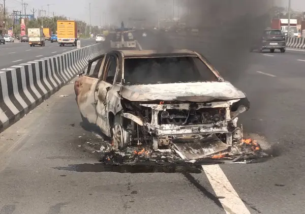 GHAZIABAD, INDIA - 26 Mart 2025 'te Delhi Meerut Otoyolu' nda, bir arabanın lastikleri patladıktan sonra hasar gören bir Baleno arabası aniden alev aldı ve 26 Mart 2025 'te Hindistan' ın Gaziabad kentinde tüm araba alev aldı.. 
