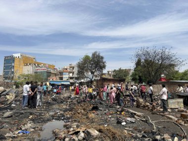 GURUGRAM, INDIA - 29 Mart 2025: 29 Mart 2025 'te Hindistan' ın Gurugram kentinde, Basai Enclave sektörü 9B 'de büyük bir yangının çıktığı bir siteden insanlar kömür çıkardılar. Bu olayda kimse yaralanmadı..