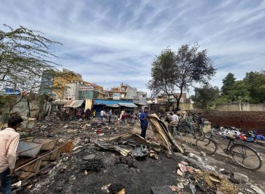 GURUGRAM, INDIA - 29 Mart 2025: 29 Mart 2025 'te Hindistan' ın Gurugram kentinde, Basai Enclave sektörü 9B 'de büyük bir yangının çıktığı bir siteden insanlar kömür çıkardılar. Bu olayda kimse yaralanmadı..