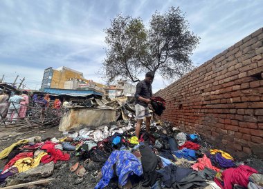 GURUGRAM, INDIA - 29 Mart 2025: 29 Mart 2025 'te Hindistan' ın Gurugram kentinde, Basai Enclave sektörü 9B 'de büyük bir yangının çıktığı bir siteden insanlar kömür çıkardılar. Bu olayda kimse yaralanmadı..