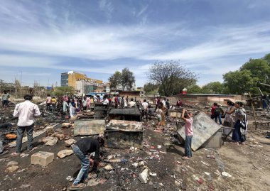 GURUGRAM, INDIA - 29 Mart 2025: 29 Mart 2025 'te Hindistan' ın Gurugram kentinde, Basai Enclave sektörü 9B 'de büyük bir yangının çıktığı bir siteden insanlar kömür çıkardılar. Bu olayda kimse yaralanmadı..