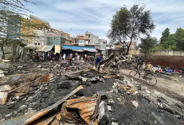 GURUGRAM, INDIA - 29 Mart 2025: 29 Mart 2025 'te Hindistan' ın Gurugram kentinde, Basai Enclave sektörü 9B 'de büyük bir yangının çıktığı bir siteden insanlar kömür çıkardılar. Bu olayda kimse yaralanmadı..