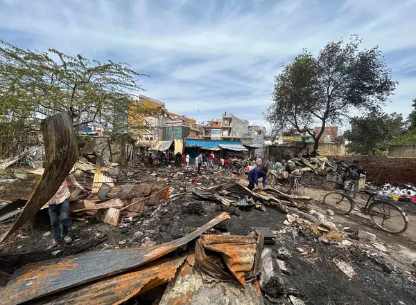 GURUGRAM, INDIA - 29 Mart 2025: 29 Mart 2025 'te Hindistan' ın Gurugram kentinde, Basai Enclave sektörü 9B 'de büyük bir yangının çıktığı bir siteden insanlar kömür çıkardılar. Bu olayda kimse yaralanmadı..