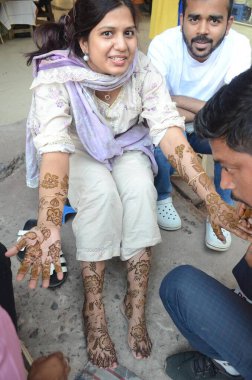 PATNA, INDIA - 30 Mart 2025 'te Maurya Lok Kompleksi' nde Kurban Bayramı arifesinde Mehndi 'ye başvuran Müslüman kadın.