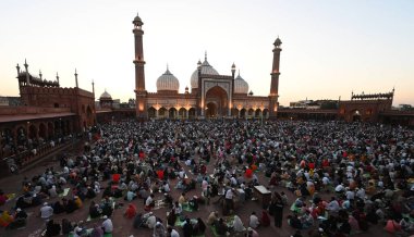 YENİ DELHI, INDIA - 30 Mart 2025 'te Hindistan' ın Yeni Delhi kentinde Müslümanlar Ramazan Ramazan Ramazan ayının son gününde Aydınlanmış Jama Mescidi önünde oruç tutuyorlar.. 