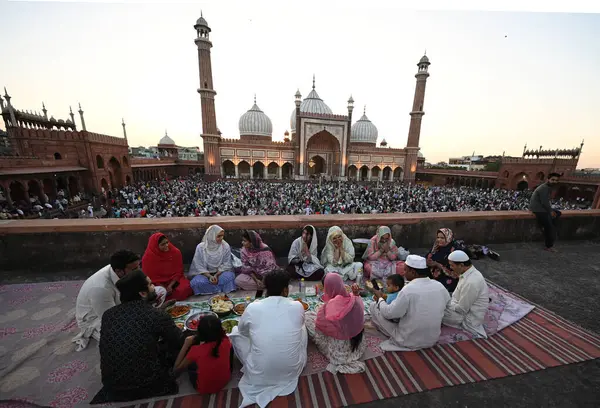 YENİ DELHI, INDIA - 30 Mart 2025 'te Hindistan' ın Yeni Delhi kentinde Müslümanlar Ramazan Ramazan Ramazan ayının son gününde Aydınlanmış Jama Mescidi önünde oruç tutuyorlar.. 