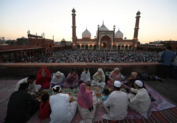 YENİ DELHI, INDIA - 30 Mart 2025 'te Hindistan' ın Yeni Delhi kentinde Müslümanlar Ramazan Ramazan Ramazan ayının son gününde Aydınlanmış Jama Mescidi önünde oruç tutuyorlar.. 