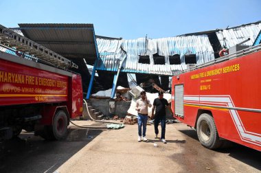 2 Nisan 2025 'te Gurugram, Hindistan' da, Pataudi Yolu 'ndaki Radha Soami Bhawan yakınlarındaki Kadipur Endüstriyel Bölgesi' ndeki fabrika deposunda çıkan yangını söndürmeye çalışan itfaiye personeli görülüyor.