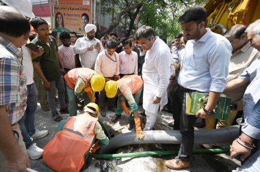 NEW DELHI, INDIA - 6 Nisan 2025: Delhi PWD Bakanı Parvesh Verma, 6 Nisan 2025 tarihinde Hindistan 'ın Yeni Delhi kentinde, Kailash Kolonisi Metro İstasyonu yakınlarındaki Zamrudpur köyündeki kanalizasyon temizliğini denetliyor..
