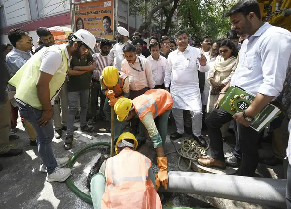 NEW DELHI, INDIA - 6 Nisan 2025: Delhi PWD Bakanı Parvesh Verma, 6 Nisan 2025 tarihinde Hindistan 'ın Yeni Delhi kentinde, Kailash Kolonisi Metro İstasyonu yakınlarındaki Zamrudpur köyündeki kanalizasyon temizliğini denetliyor..