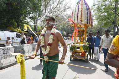 NEW DELHI, INDIA - 11 Nisan 2025: Bir ayin kapsamında yanakları metal çubuk takılı insanlar, Hindu tanrısı Murugan onuruna düzenlenen Panguni Uthiram festivali vesilesiyle düzenlenen törene katılın.. 
