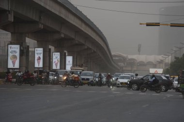 GURUGRAM, INDIA - 11 Nisan 2025: Hindistan 'ın Gurugram şehrinde 11 Nisan 2025 tarihinde, DLF faz-5 yakınlarındaki Golf course Road' da araç toz fırtınasının ortasında hareket eder. Şiddetli kum fırtınaları ve şiddetli rüzgarları Cuma akşamı başkente yağan yağmur izliyor.