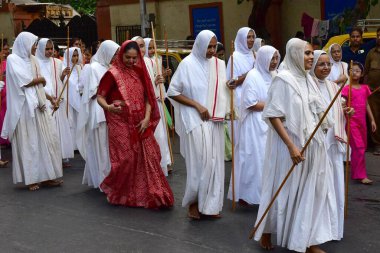 MUMBAI, INDIA - 10 Nisan 2025: Jain fanatikleri, Mahavir Jayanti 'nin doğum yıldönümü münasebetiyle 10 Nisan 2025 tarihinde, Hindistan' ın Mumbai kentinde, Mazagaon bölgesinde, Mazagaon bölgesinde, Mahavir Jayanti 'nin heykeli eşliğinde bir tahtırevana katıldılar..