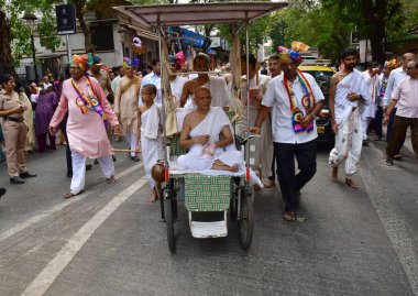 MUMBAI, INDIA - 10 Nisan 2025: Jain fanatikleri, Mahavir Jayanti 'nin doğum yıldönümü münasebetiyle 10 Nisan 2025 tarihinde, Hindistan' ın Mumbai kentinde, Mazagaon bölgesinde, Mazagaon bölgesinde, Mahavir Jayanti 'nin heykeli eşliğinde bir tahtırevana katıldılar..