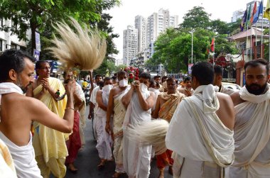 MUMBAI, INDIA - 10 Nisan 2025: Jain fanatikleri, Mahavir Jayanti 'nin doğum yıldönümü münasebetiyle 10 Nisan 2025 tarihinde, Hindistan' ın Mumbai kentinde, Mazagaon bölgesinde, Mazagaon bölgesinde, Mahavir Jayanti 'nin heykeli eşliğinde bir tahtırevana katıldılar..