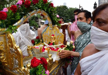 MUMBAI, INDIA - 10 Nisan 2025: Jain fanatikleri, Mahavir Jayanti 'nin doğum yıldönümü münasebetiyle 10 Nisan 2025 tarihinde, Hindistan' ın Mumbai kentinde, Mazagaon bölgesinde, Mazagaon bölgesinde, Mahavir Jayanti 'nin heykeli eşliğinde bir tahtırevana katıldılar..