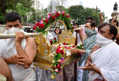 MUMBAI, INDIA - 10 Nisan 2025: Jain fanatikleri, Mahavir Jayanti 'nin doğum yıldönümü münasebetiyle 10 Nisan 2025 tarihinde, Hindistan' ın Mumbai kentinde, Mazagaon bölgesinde, Mazagaon bölgesinde, Mahavir Jayanti 'nin heykeli eşliğinde bir tahtırevana katıldılar..