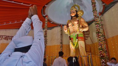MUMBAI, INDIA - 12 Nisan 2025 'te Hindistan' ın Mumbai kentinde Hanuman Jayanti 'nin Ghodbunder Road Owala köyünde gerçekleştirdiği etkinlikte Tanrı Hanuman' ın 10 metrelik putuna ibadet edenler. Hanuman Jayanti, Tanrı Hanuman 'ın doğumunu kutluyor.