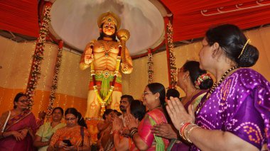 MUMBAI, INDIA - 12 Nisan 2025 'te Hindistan' ın Mumbai kentinde Hanuman Jayanti 'nin Ghodbunder Road Owala köyünde gerçekleştirdiği etkinlikte Tanrı Hanuman' ın 10 metrelik putuna ibadet edenler. Hanuman Jayanti, Tanrı Hanuman 'ın doğumunu kutluyor.