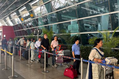 NEW DELHI, INDIA - 12 Nisan 2025 'te Hindistan' ın Yeni Delhi kentinde dünkü toz fırtınasından sonra birkaç uçuşun ertelenmesiyle IGI 'nin T2' sinde kuyrukta bekleyen yolcular görülüyor.. 