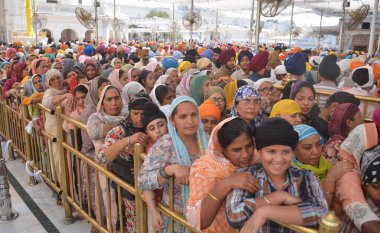 AMRITSAR, INDIA - 13 Nisan 2025: Bağımlılar, 13 Nisan 2025 tarihinde Hindistan 'ın Amritsar kentinde, Altın Tapınak' ta düzenlenen Baisakhi festivali vesilesiyle saygılarını sunuyorlar. Vaisakhi, diğer adıyla Baisakhi, Vaisakh ayının başlangıcını müjdeliyor..