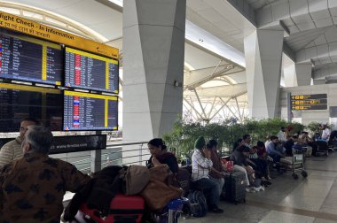 NEW DELHI, INDIA - 12 Nisan 2025 'te Hindistan' ın Yeni Delhi kentinde dünkü toz fırtınasından sonra birkaç uçuşun ertelenmesiyle IGI 'nin T2' sinde kuyrukta bekleyen yolcular görülüyor.. 