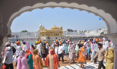 AMRITSAR, INDIA - 13 Nisan 2025: Bağımlılar, 13 Nisan 2025 tarihinde Hindistan 'ın Amritsar kentinde, Altın Tapınak' ta düzenlenen Baisakhi festivali vesilesiyle saygılarını sunuyorlar. Vaisakhi, diğer adıyla Baisakhi, Vaisakh ayının başlangıcını müjdeliyor..