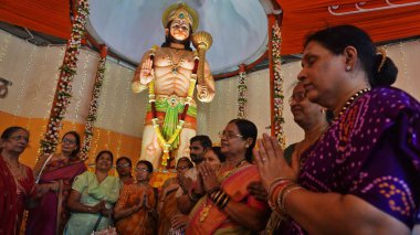 MUMBAI, INDIA - 12 Nisan 2025 'te Hindistan' ın Mumbai kentinde Hanuman Jayanti 'nin Ghodbunder Road Owala köyünde gerçekleştirdiği etkinlikte Tanrı Hanuman' ın 10 metrelik putuna ibadet edenler. Hanuman Jayanti, Tanrı Hanuman 'ın doğumunu kutluyor.