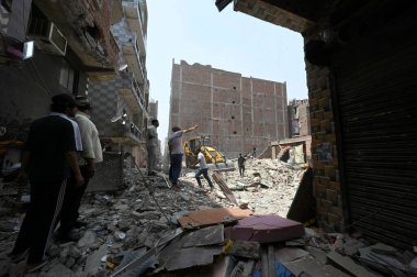 NEW DELHI INDIA APRIL 20 2025 Yerel halk, 20 Nisan 2025 'te Mustafabad bölgesinde çöken bir binanın ertesi günü, Hindistan' da 4 'ü çocuk en az 11 kişinin öldüğü, 11' inin ise yaralandığı bölgede duruyor.